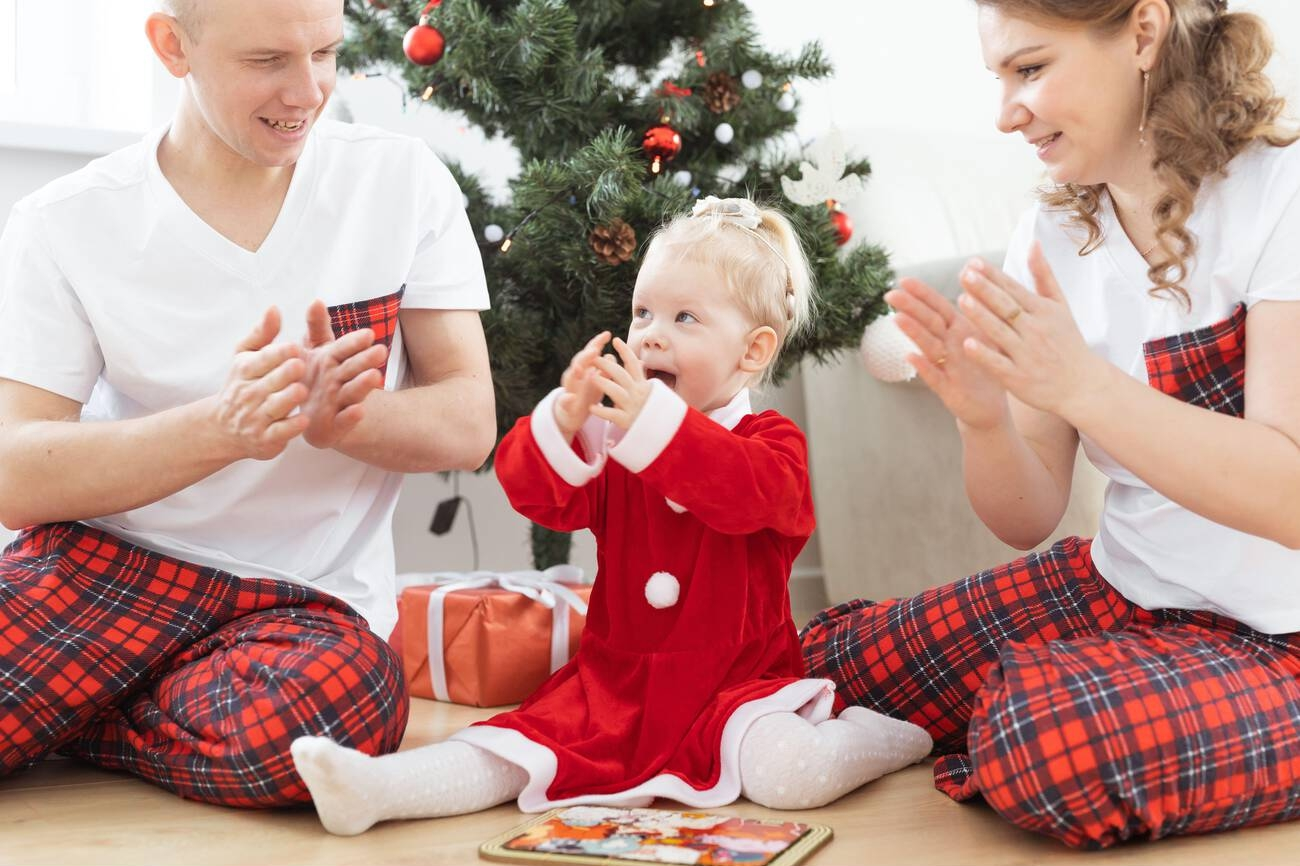 a_family_sitting_around_a_christmas_tree_playing_a_card_game.