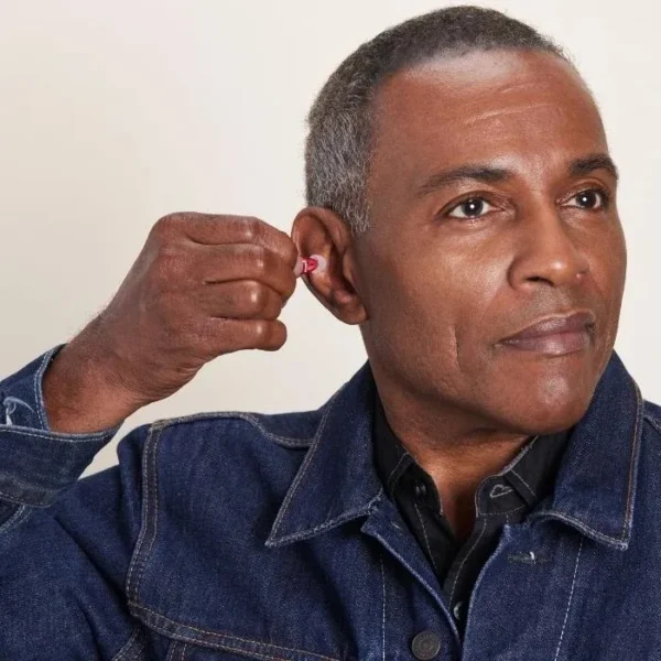 a_man_inserting_audicus_mini_hearing_aid__on_his_ear
