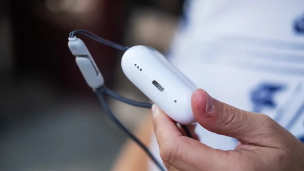 a_person_holding_a_cell_phone_in_their_hand_airpods_pro_2