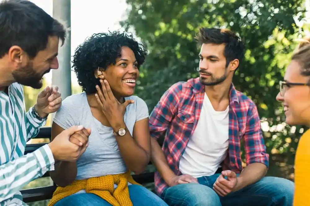 three_friends_sitting_on_a_bench_talking_and_laughing.